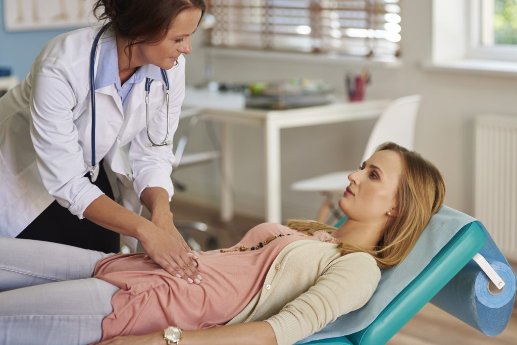 a doctor assessing a women's pelvic floor health.