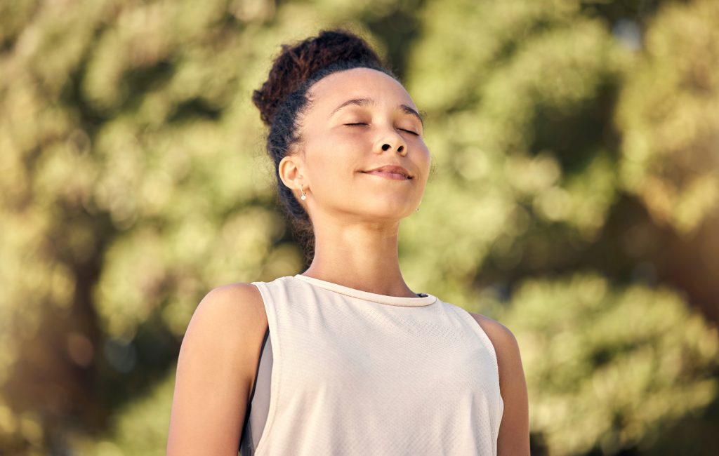 a woman taking a breath with a smile as she works towards a healthier body.