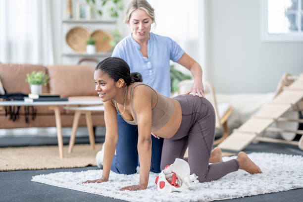 A female physiotherapist works with a pregnant woman using a personalized pelvic floor treatment plan.