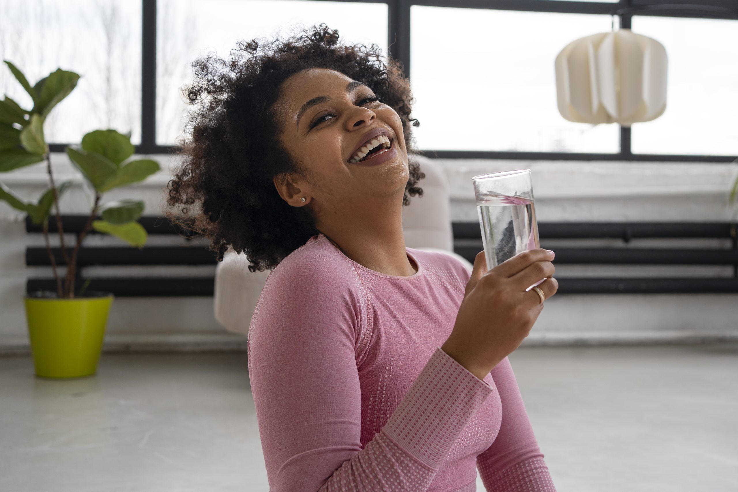 An African American woman drinking water.