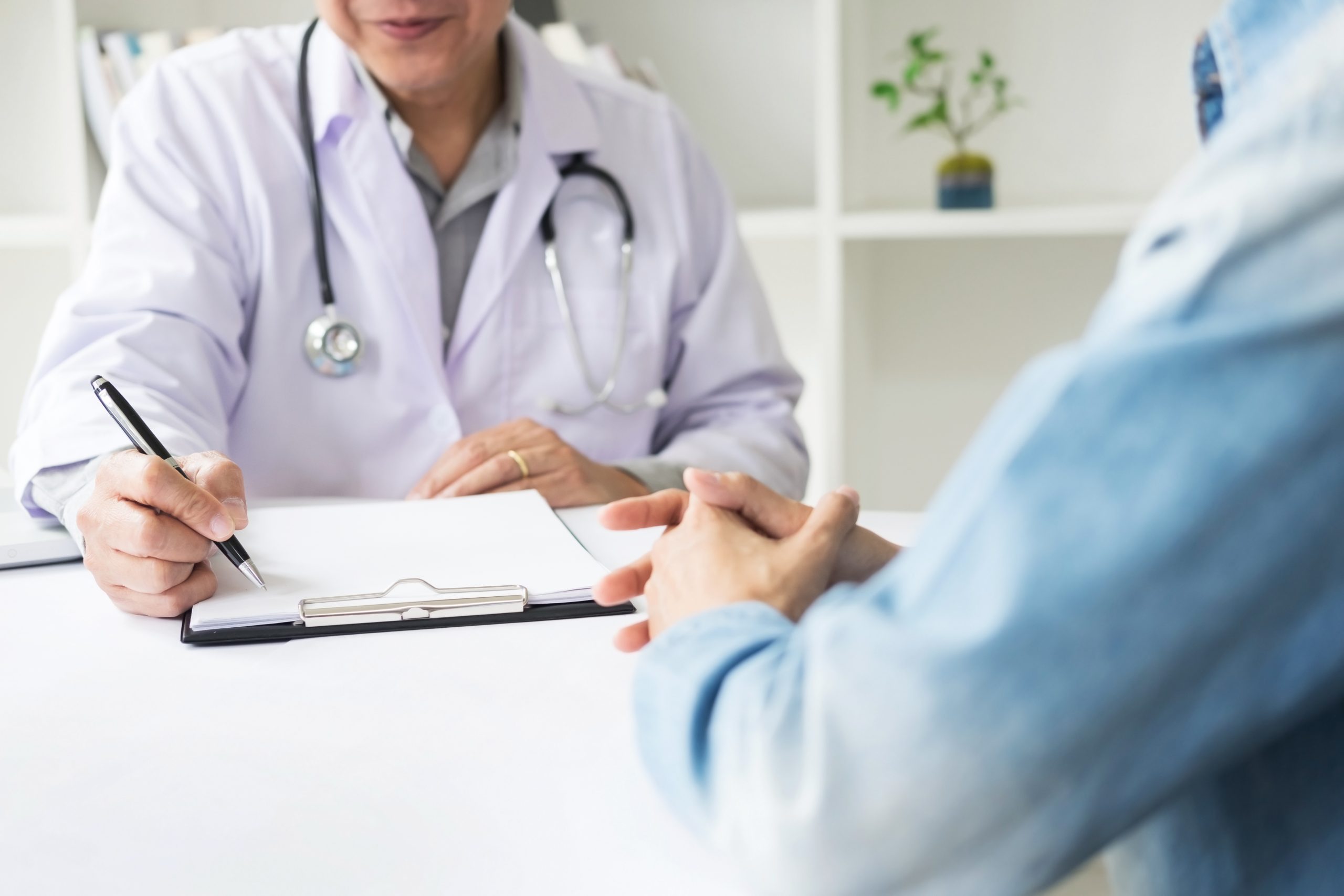 patient listening intently to a female doctor explaining patient symptoms about his pelvic floor symptoms.