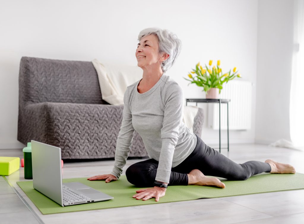 an older woman doing pelvic floor exercises from her laptop.
