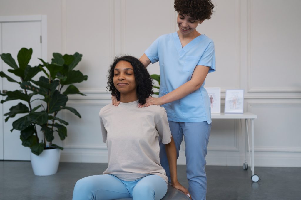 A physiotherapist helping a woman exercise.