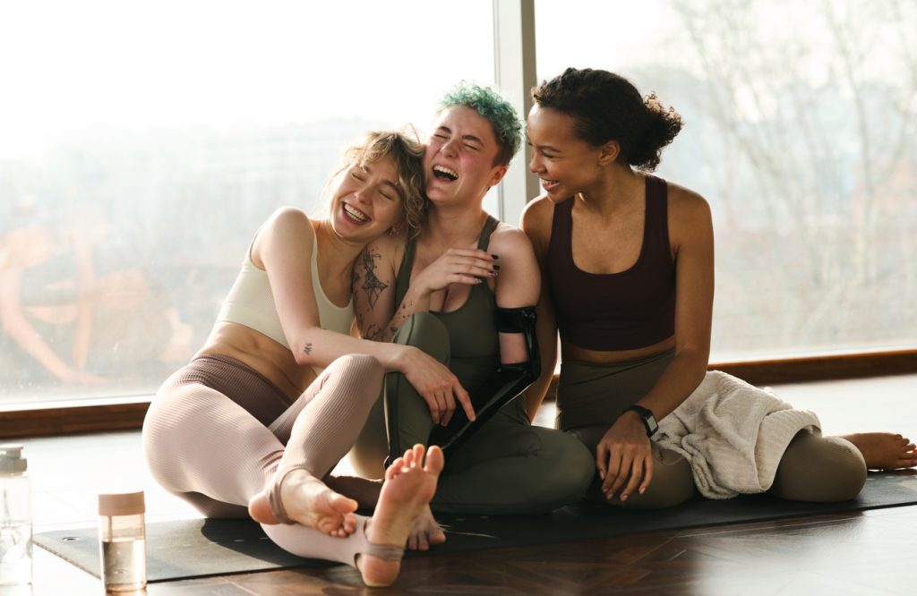 Three girls laughing after a workout/physiotherapy. This image represents a healthy lifestlye and community.